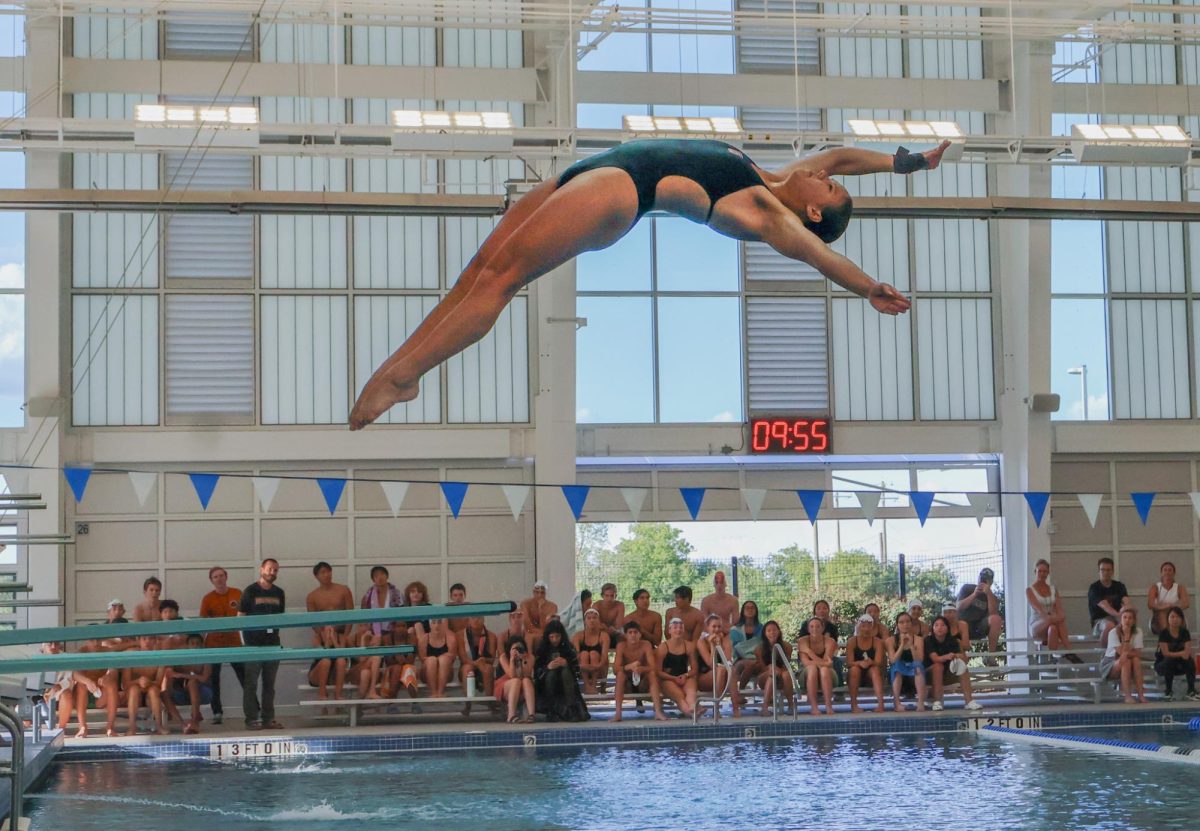 Jazzlyn Vaughan '26 launches majestically into the air in the diving event. Her graceful form and precise control demonstrates years of practice, as she momentarily defies gravity before elegantly piercing the water's surface.