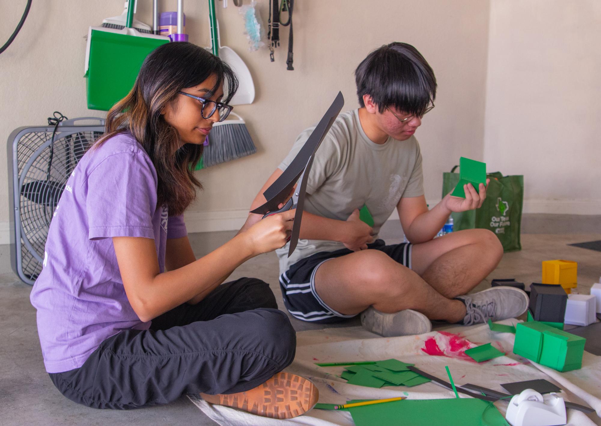 Focused on perfecting the preparation of their crafting materials, StuCo Junior Class Vice President Reva Chandane and Secretary Ryan Gu work on constructing their Minecraft-themed float. The volunteers worked hard to ensure that their float effectively portrayed the desired theme, and was fun and interactive in anticipation of the upcoming parade. 