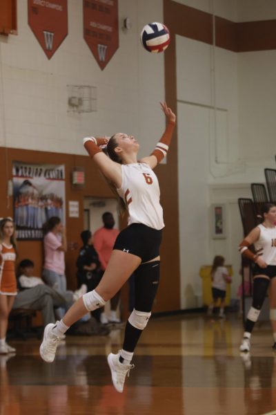 Concentrating, Kate Petty '26 raises her hand to serve the ball. Petty remained consistent with powerful hits throughout the game. "After I got my first kill, I said to my teammates, 'that was a breath of fresh air'," Petty said.