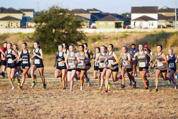 Taking off, varsity girls lead the 5,000 meter run. The varsity girls team placed 5th overall in the district competition. "My favorite thing about cross country is the girls and how much we have gotten to each other," Captain Theresa Bell '26 said.