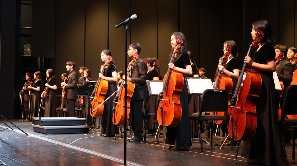 Smiling, Symphony cellist Elizabeth Hsu '25 faces the audience after completing their final piece, 'Stepping Out' by Edward Gregson. Symphony Orchestra was greeted by a thunderous round of applause after displaying skill throughout the whole performance. 