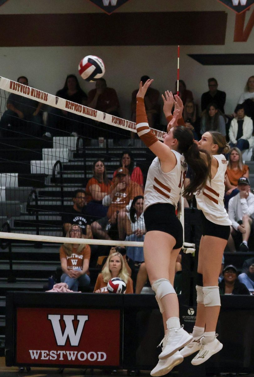 Collaborating, Grace McCluskey '26 and Piper Evans '27 both reach up to block a hit from the Round Rock Dragons. As middle blockers, McCluskey and Evans worked together for defense.