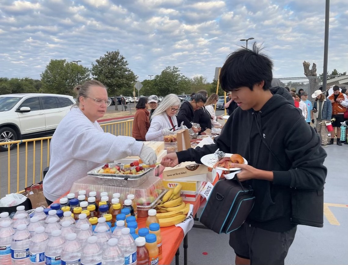 Collecting his food, Owen Sun ‘27 thanks a band parent after a morning rehearsal. The band hosts an annual homecoming breakfast each year the morning of the homecoming game.