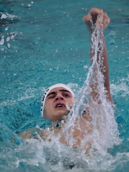 Jett Henson '28 powers through his backstroke event, refusing to let a goggle malfunction slow him down. With one eye squinting against the water and sheer determination on his face, Henson pushes towards the finish line.