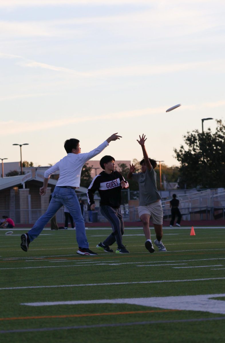 Stepping forward, Vince Pham '25 throws the frisbee to a teammate. IB students were coached in the sport by Dr. Joshua Plocher. 