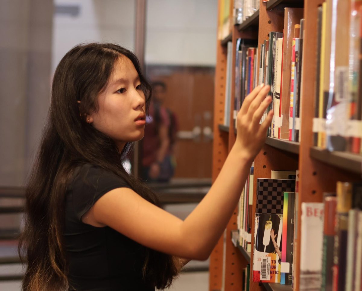 Reading the barcodes of the books, Lulu Szeto '26 checks the bookshelves in the Library Great Room. Szeto was highly engaged in the event, organizing many books in this Outreach tradition. "I liked how we were able to organize and make it easier for people to find the books that they want to find," Szeto said. "I also just like organizing in general."