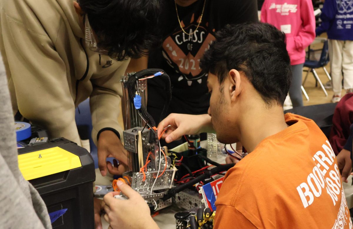 Holding a hex key, Adwik Rath ’28 from Team Boomerang adjusts a part on his robot. Boomerang’s robot underwent lots of stress during matches, meaning Rath spent lots of time repairing it between matches so it could make it through the day.