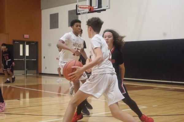 Running toward the hoop, Miles Fustes '28 swerves his opponent. The Warriors kept up a good offense and defense throughout the game, allowing them to win 65-32.