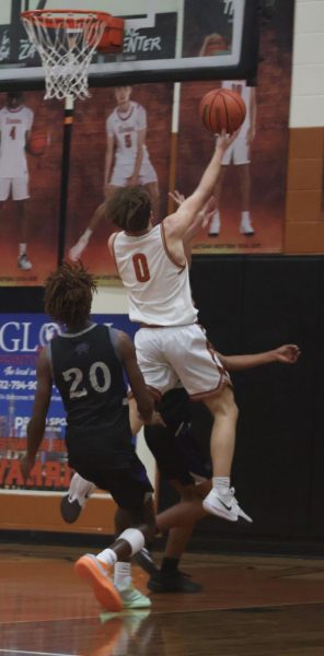 Leaping into the air, Charlie King '27 reaches for the net against the Cedar Ridge Raiders. The Warriors went on to continue to dominate the game, winning 60-34. 