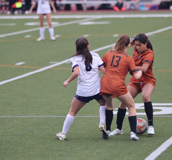 Pushing against Raider offense, Defender Erin Lott '28 protects the ball, allowing Forward Misha Baxamoosa '28 to regain possession for the Warriors. Both Warrior offense and defense worked seamlessly together to score four goals and keep the Raider score to a zero. 