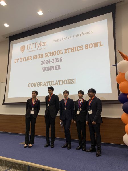 Standing proudly on top of the stage, Apple Ma '28, Viraj Gadiya '26, Levi Kim '27, Joshua Boersema '27 and Aditya Bhadra '28 (left to right) accept being named finalists of the U.T. Tyler Ethics Bowl Competition. The team had competed through three rounds of preliminary competition and a semifinals round to earn their spot in finals. 