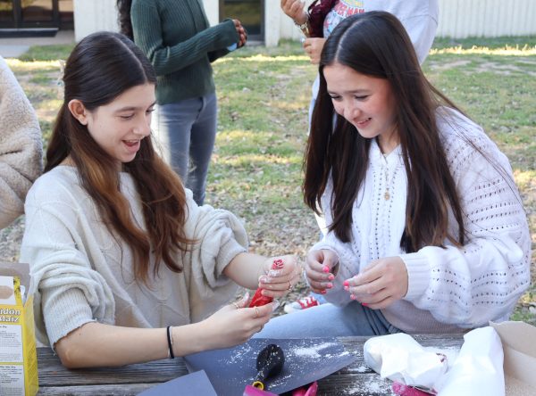 Smiling, Millie Sardan Toro '28 examines her burst balloon as Kyla Cretencio '28 laughs. Although the pair made separate stress balls, they were able to bond over the creative endeavor.