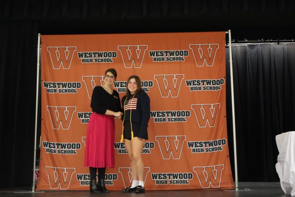 Shaking hands, Associate Principal Sarah Lowery and Izzy Horonzy '26 smile for a picture. Each new member took a picture with the associate principal as a celebration and certification of their induction.