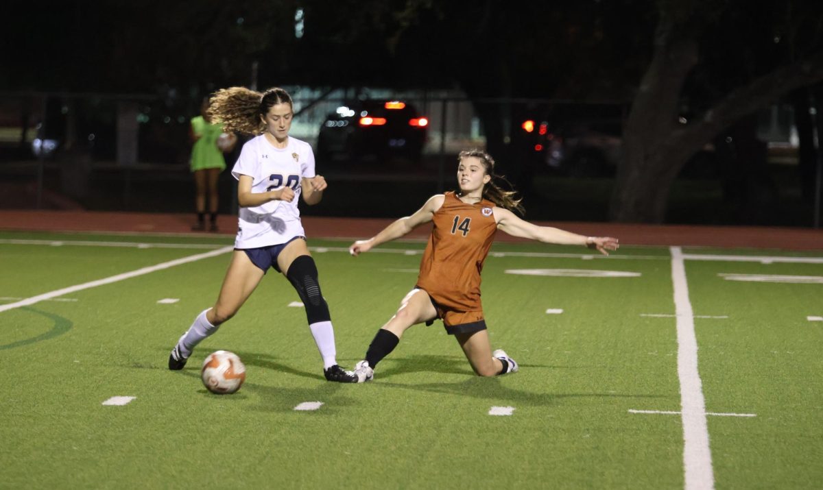 Lunging for the ball, Audrey Savoie '26 tries to gain possession of the ball. Communication and good touches played a big role in the 5-0 win for Westwood.