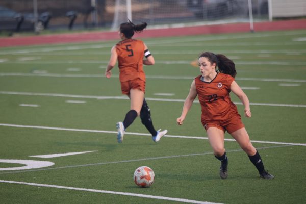 Receiving the ball from Defender Jackson Bowen '26, Defender Madeleine Ziegler '27 moves to shoot the ball into the goal. The Warriors utilized powerful offense and defense alike to score six goals while keeping Tiger points to a zero. 