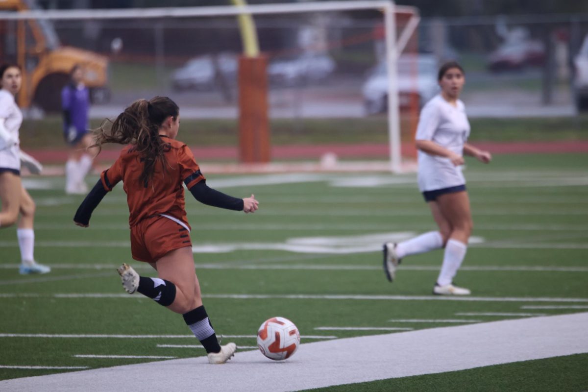 Swinging to shoot the ball towards the Maverick net, Defender Ella Smith '27 prepares to kick the ball. Smith played a pivotal role in aiding her teammates move the ball down the field in long strides without losing possession to the Mavericks. 