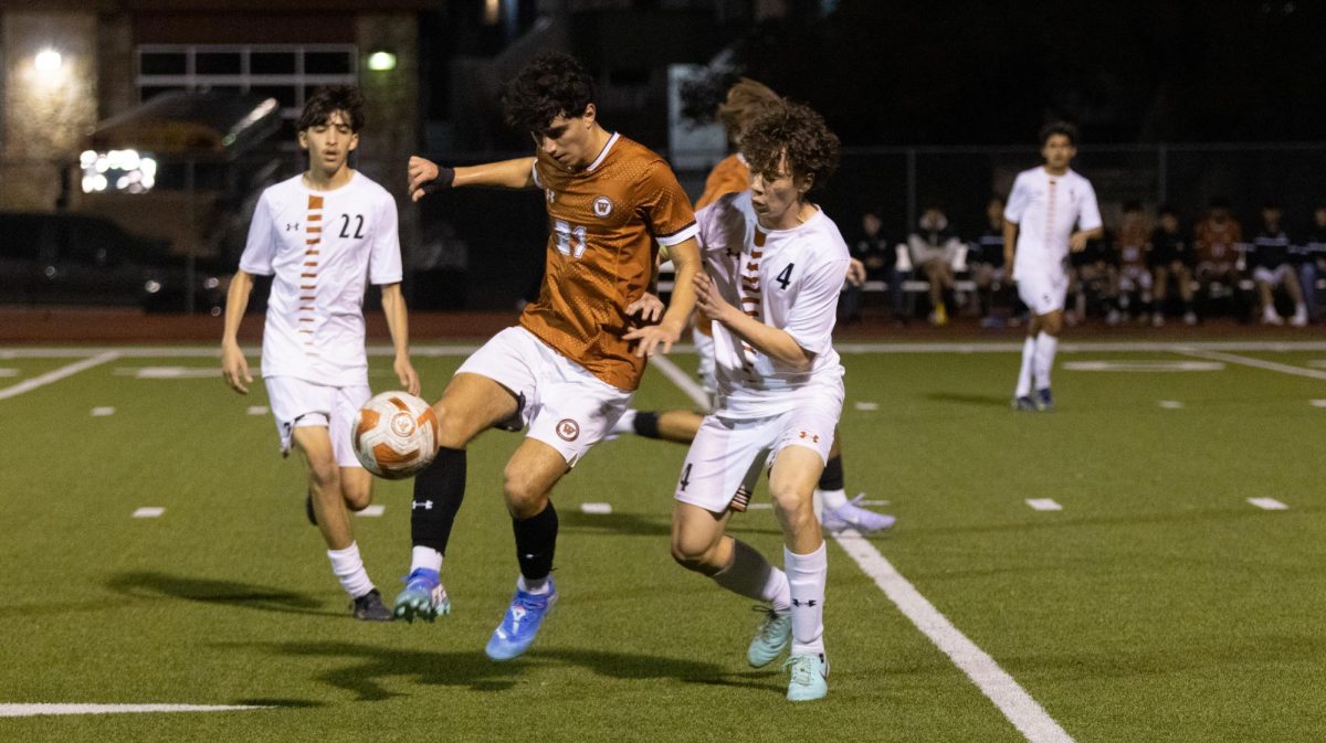 Jumping in the air, Rodrigo Garcia ‘26 blocks a Hutto player. Garcia attempted many shots throughout the game.