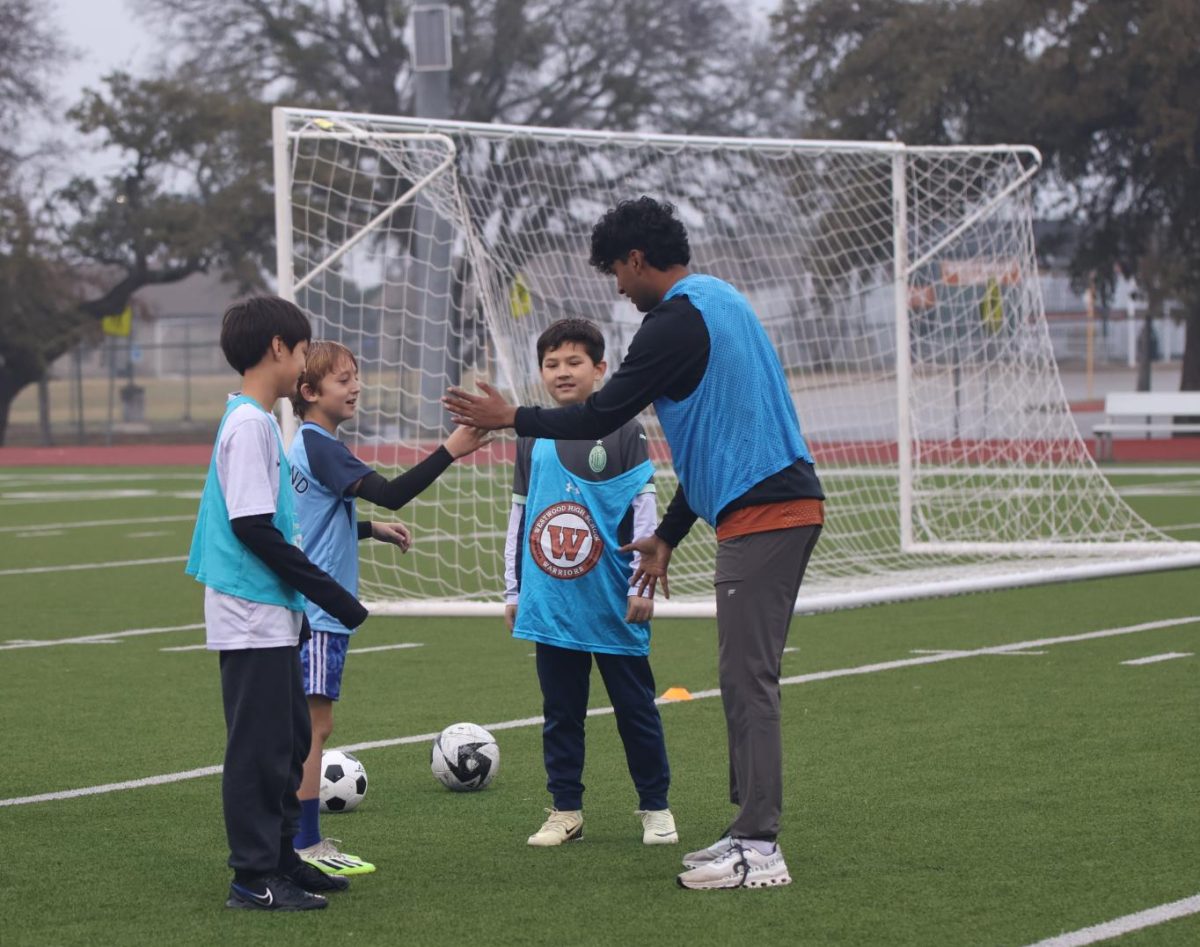 High fiving his young teammate, Romir Jain ‘25 celebrates a goal with his team during a scrimmage. The Warriors served as role models and mentors for the kids who came to the event.