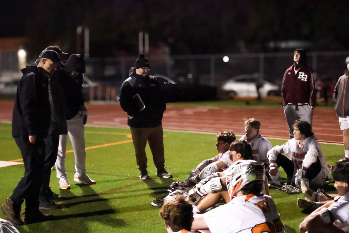 Consoling the players, Defensive Coordinator Justin Becker congratulates the players for their explosive fourth quarter comeback. Even though the Warriors were down 8-1 by the beginning of the quarter, the Warrior offense allowed the score to be brought up to 8-5 at the end of regulation.