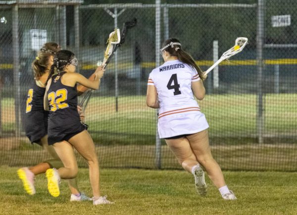 With two Tigers on her heels, defensive player Elly Howell '26 takes the ball around the net in hopes of making a pass. During the game, both defense and offense positions played smarter through every quarter. "Usually we're not as smart about our passes, but this game we got more open. We got more passes and more shooting able to happen, more teamwork happening this game," Howell said. 