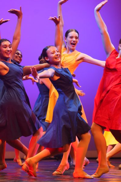 Smiling bright, Alicia  Kanazawa de Figueiredo ‘25 poses with both hands up, staying in sync with her teammates. During the Warrior Pride’s "Another Day of Sun" dance performance, the whole team had to work together to match up the timing to make the dance look organized and synchronized. “The dance is just really fun and energetic, and I love this song so much,” Kanazawa de Figueiredo said. 