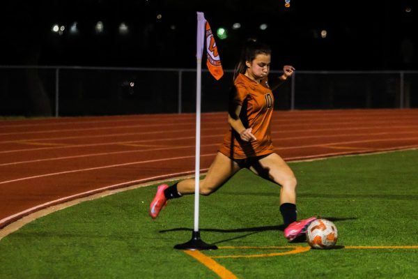 Swinging her leg, Mia Wiele '26 takes a corner kick. Throughout the game, Wiele also took a penalty kick for the Warriors that almost made it into the goal, but just passed above the crossbar.