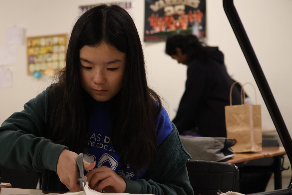 Preparing her dog toy, Mia Rhie ‘28 cuts through an old shirt. Using old t-shirts Outreach Club participated in Project Canis, a project to aid dogs in shelters.