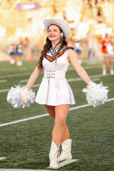Clasping two pom poms, Polly Nickens '25 strikes a pose. Holding the title of Major, Nickens has contributed immensely to the Sundancers. "It's such a great opportunity and I love getting to serve my team in the ways that I do. It's just the most incredible thing," Nickens said.