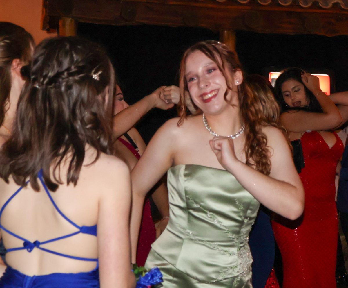 Beaming, Maya Spindler '25 dances as she looks at her friend. As the night progressed, many dancers took to the dance floor to enjoy with their friends.