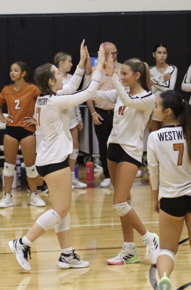 Hands in the air, Ava Hernandez '29 and Liberty Hargave '29 high-five to hype each other up during their first set. With morale and team support being crucial to the team's success, teammates utilized these small displays of encouragement to stay motivated throughout the game. 