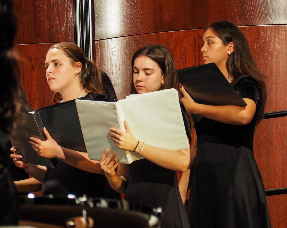Focusing on their music, Violet Vara '27 and Emery Stevens '27 perform "Gloria" by Antonio Vivaldi with their peers. On stage shined varsity choirs; Innova and Chamber, accompanied by the symphony and wind ensemble orchestras.