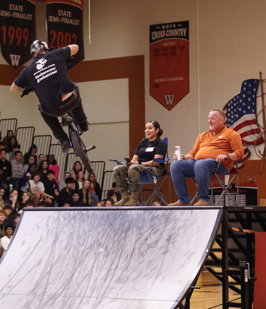 With the crowd on the edge of their seat, a BMX rider speeds up the ramp, approaching Choir Director Andre Clark and a Marine volunteer. The two were chosen to sit on the ramp as a rider jumped over them. "It was a pretty cool experience to be out there. If you're gonna have to go watch an assembly, you might as well get a front row seat," Mr. Clark said.