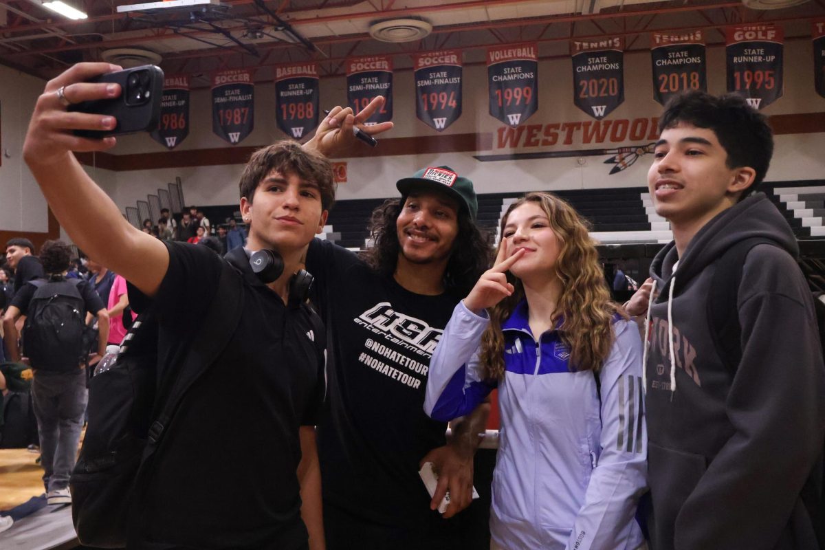 Posing for the camera after the No Place for Hate assembly, students take a selfie with one of the BMX riders. The riders took time to interact with the students after the show and handed out cards with autographs and a positive message.