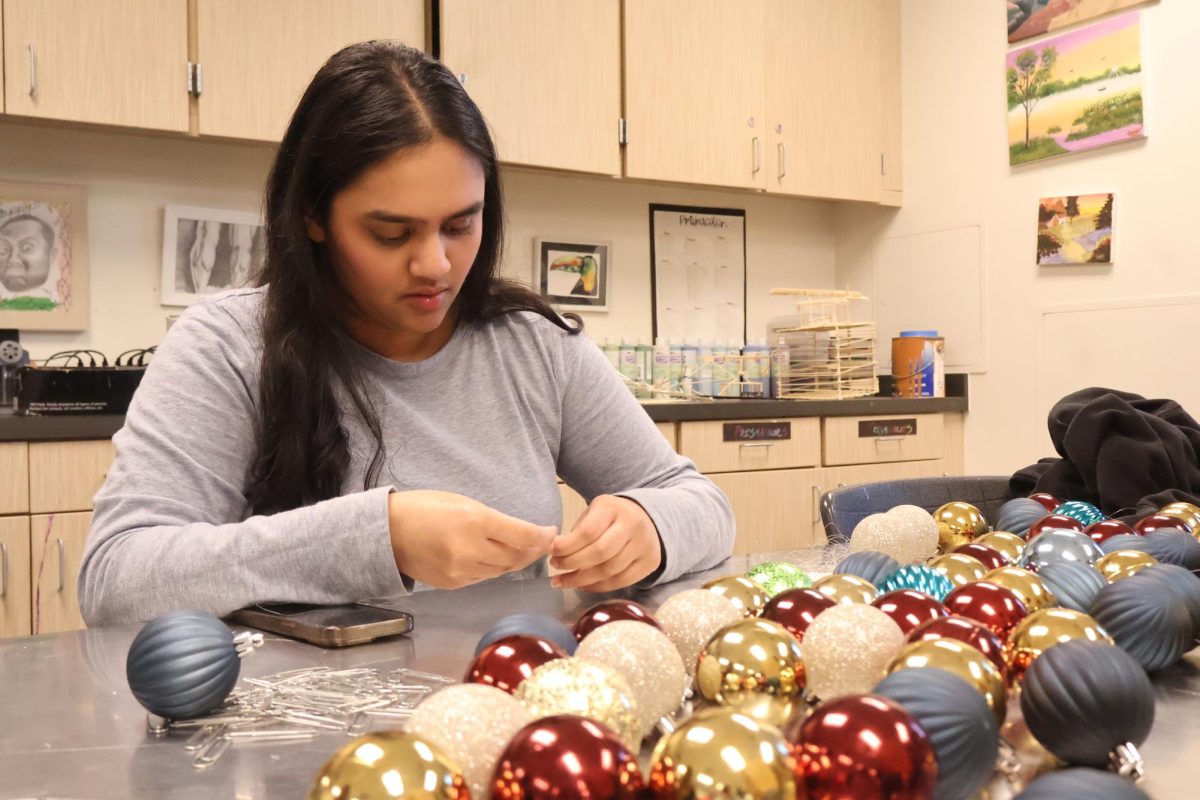 Paying close attention to detail, Serena Momin '26 carefully threads a string of fishing line through an ornament. Knowing what purpose her ornaments would serve to teachers, she worked efficiently to finish as many as she could.
