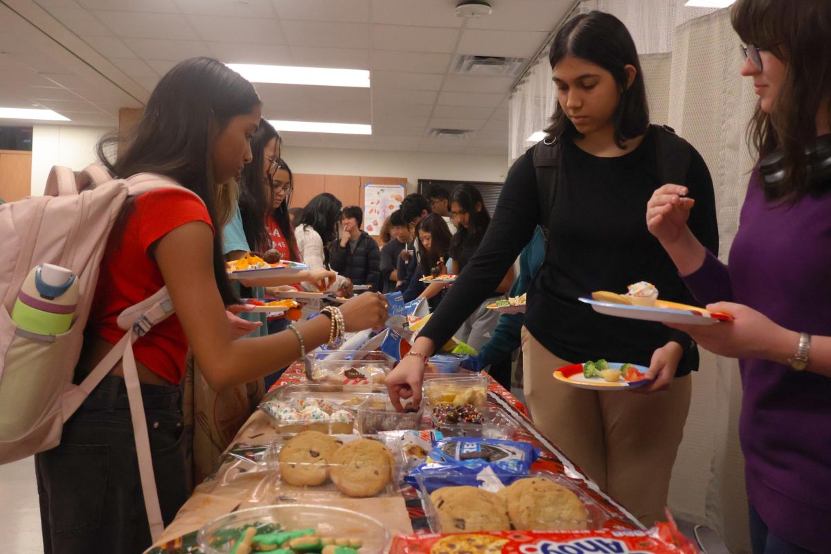 Choosing a brownie bite, Sonia Jaikeran '27 enjoys refreshments at the HOSA Winter Social. The spread of donated snacks encouraged members to linger, sparking conversation and connection across grade levels.