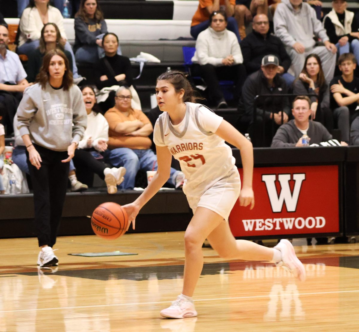 Running with the ball, Lola Montana '26 runs fast to get the ball on the other side in time before the quarter ends. This intensity shakes the Warriors from scoring a point. 