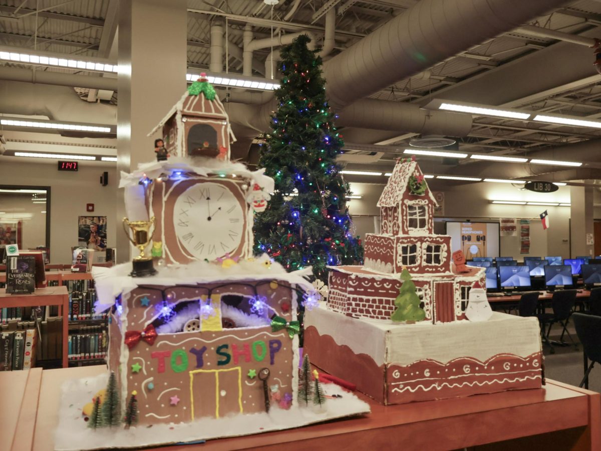 Holiday spirit filling the library, gingerbread contest entries stand in front of a brightly lit Christmas tree. The library held this contest to provide students an opportunity to celebrate the holiday season and take a break from finals. 