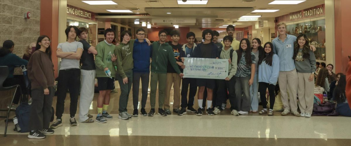 Huddled together under the main entrance, the Computer Science Club poses for a picture with the Spike creators. The club was awarded a $1000 check for their victory in the Spike competition, a collaborative effort by members of the club. 