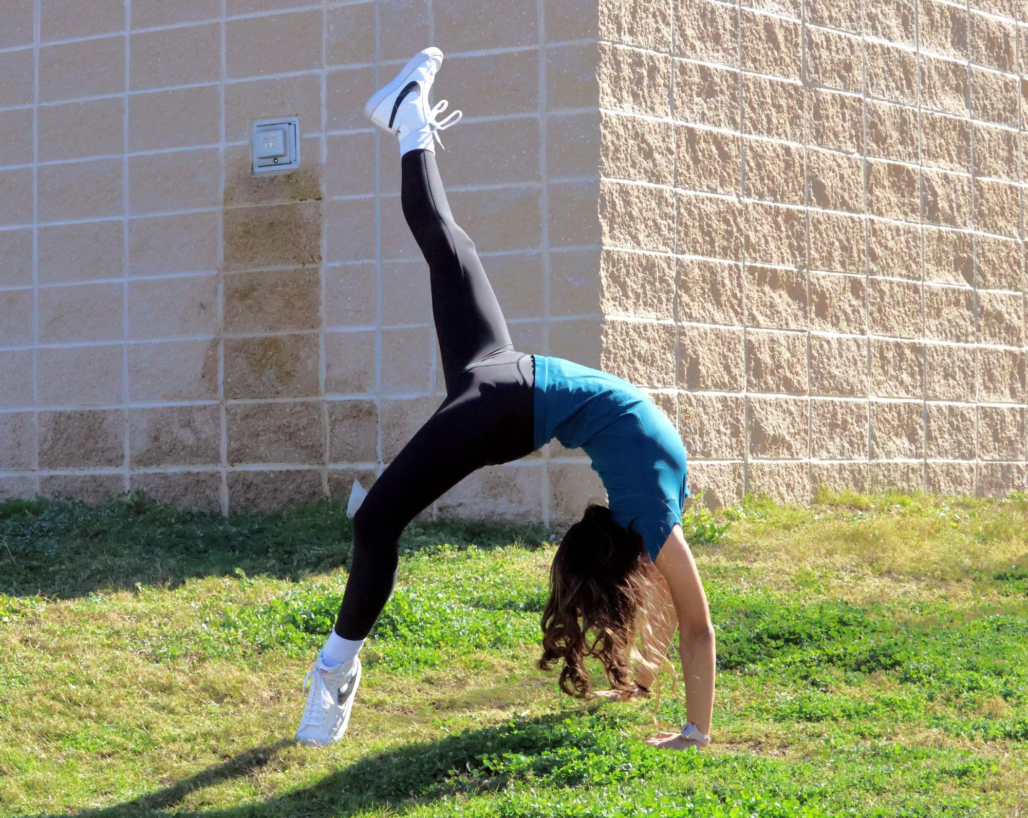 Leg kicked up, Neha Sharma '27 poses in a backbend. Neha devoted 200 hours of gymnastics to fulfill the physical fitness requirement for the Congressional Award; although multiple sprains challenged her movement, she persevered and achieved the Congressional Award Gold Medal.