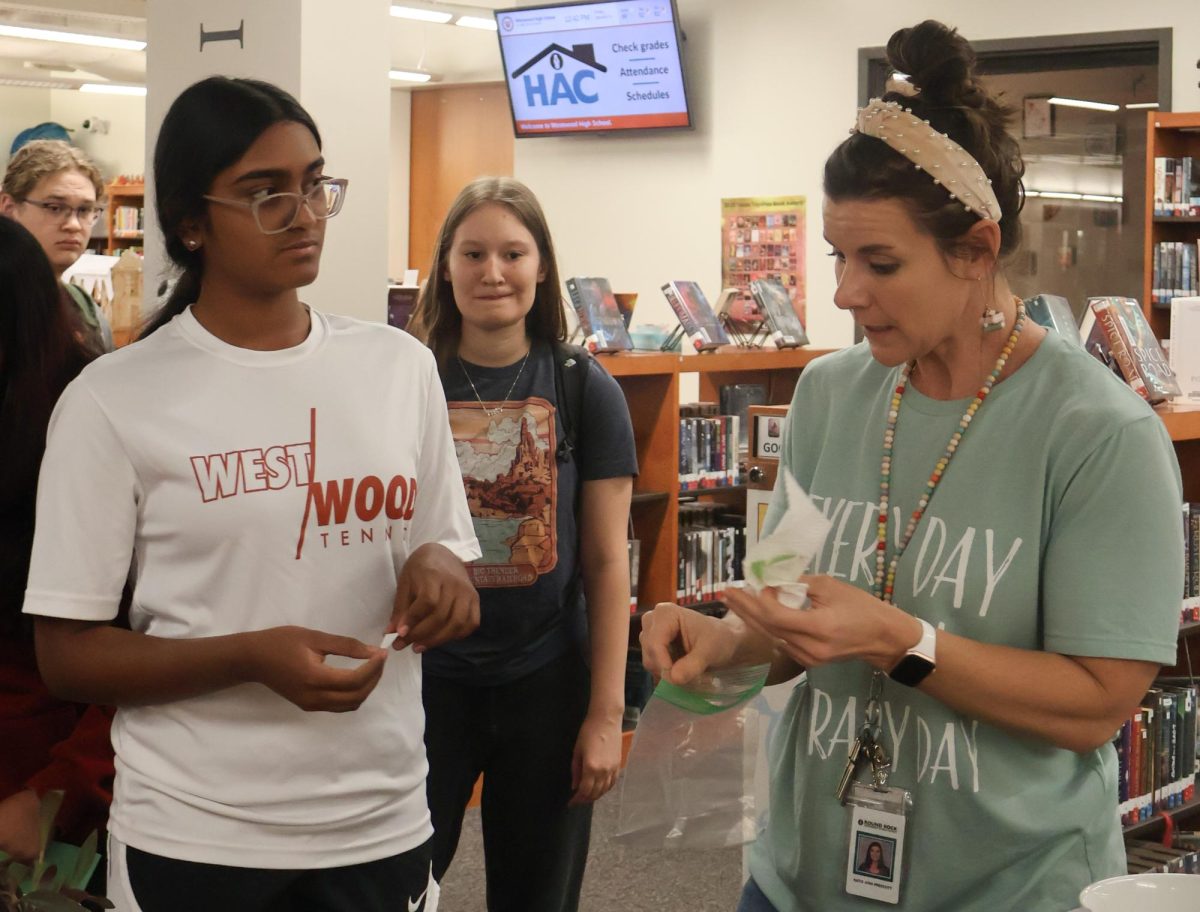 Placing a pothos cutting into a bag, Co-Librarian KatieAnn Prescott converses with Chaarukeshini Arunkumar '27. The plant swap gave students the opportunity to connect over a love of plants and start conversations with new people.