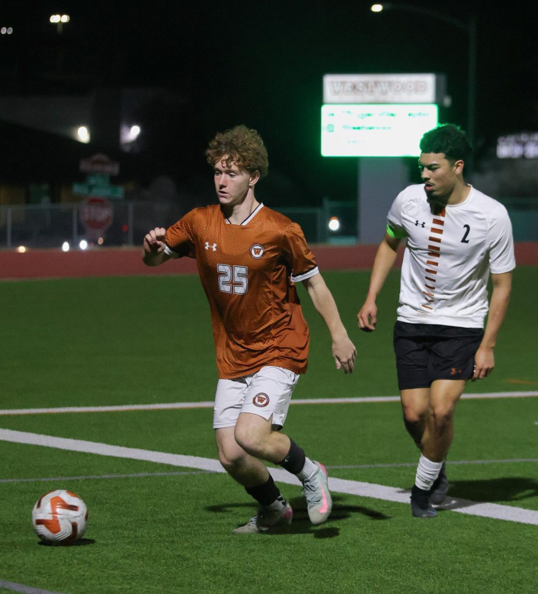 Chasing the ball, Declan O'Hanlon '27 passes by a Hutto opponent. O'Hanlon is playing his first year on varsity.
