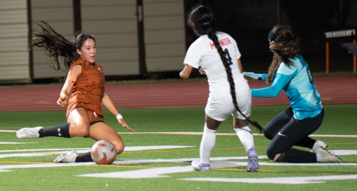 Sliding in, Kaleia Coughlin '26 searches for the best spot to aim the ball to score another goal for the Warriors. Throughout the game, the Warriors were consistently up the field and shooting for goals. 