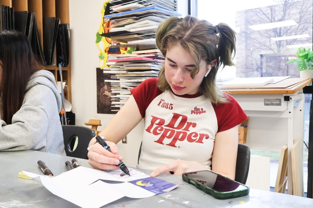 Holding a blue alcohol marker, Lila Paddock '29 draws her zine design, including elements of nature. In commemoration of Martin Luther King Jr. Day, Paddock based the purpose of her design on equality and sharing experiences, specifically through nature.
