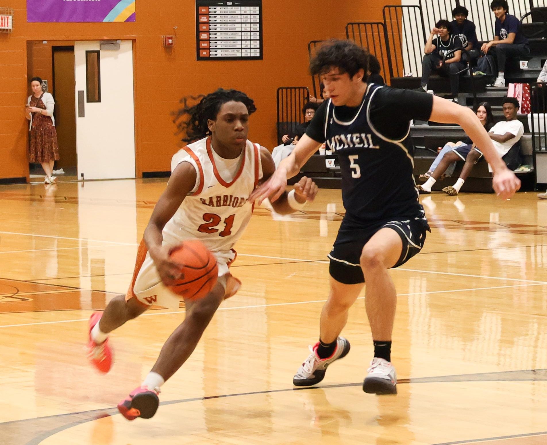 Kameron Hill '29 drives toward the basket while being closely guarded by a McNeil defender. Hill '29 fought through contact to create an offensive opportunity for the Warriors.