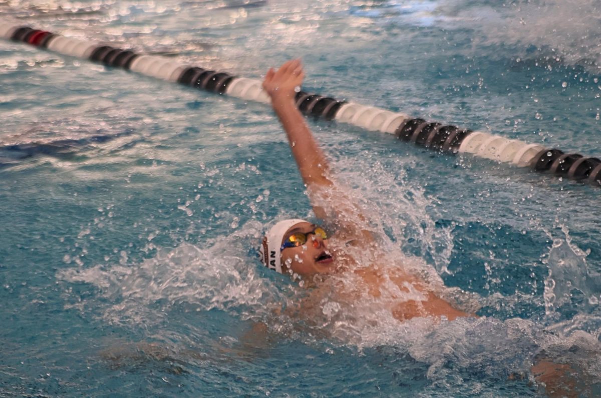 Pushing water back, Marvin Qian '29  competes in the 100 backstroke event. Encouraged by his teammates, Qian strived to do his best for him and the rest of the team.