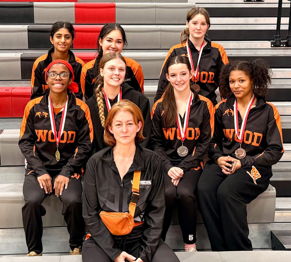 The girls team poses with their medals, alongside team mom Vanessa Beers. Taking home third place, the girls team brings new hopes and ideals alongside their triumph.