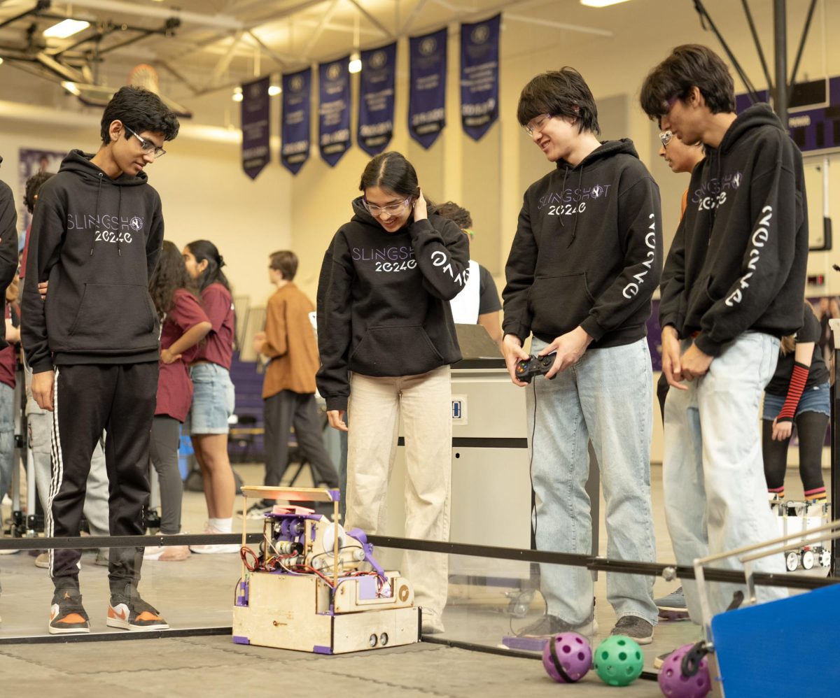 Grinning, Ishaan Desai '29, Rupal Jain '27, Viktor Nguyen '26, and Arhaan Jafri '27 look on with pride as their robot completes a practice run. This pre-game ritual helped the robot drivers and drive coach relax and get into the rhythm of the matches before the stakes rose.