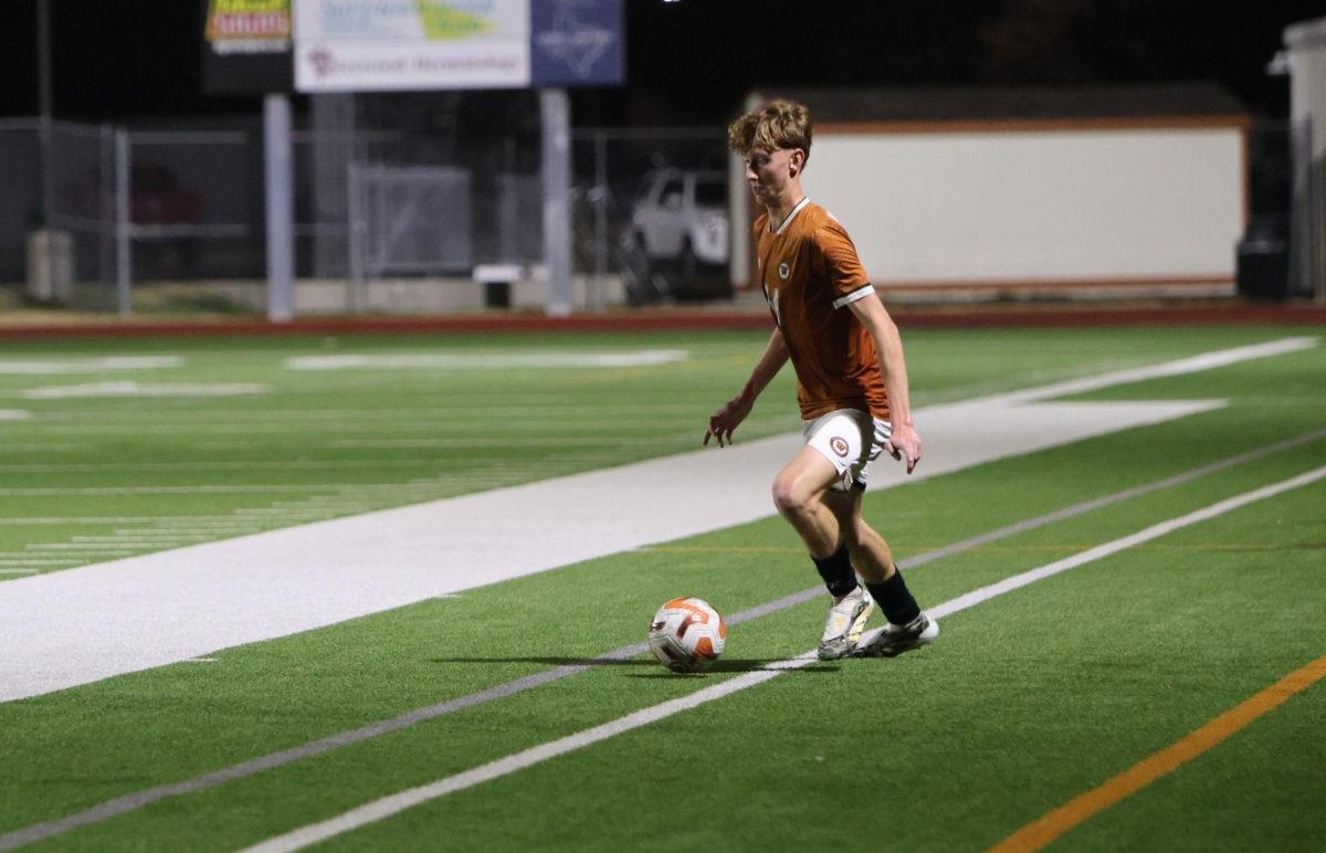 Taking a running start, Nolin Loftin ‘26 prepares to kick the ball. Loftin was a starter for the game.