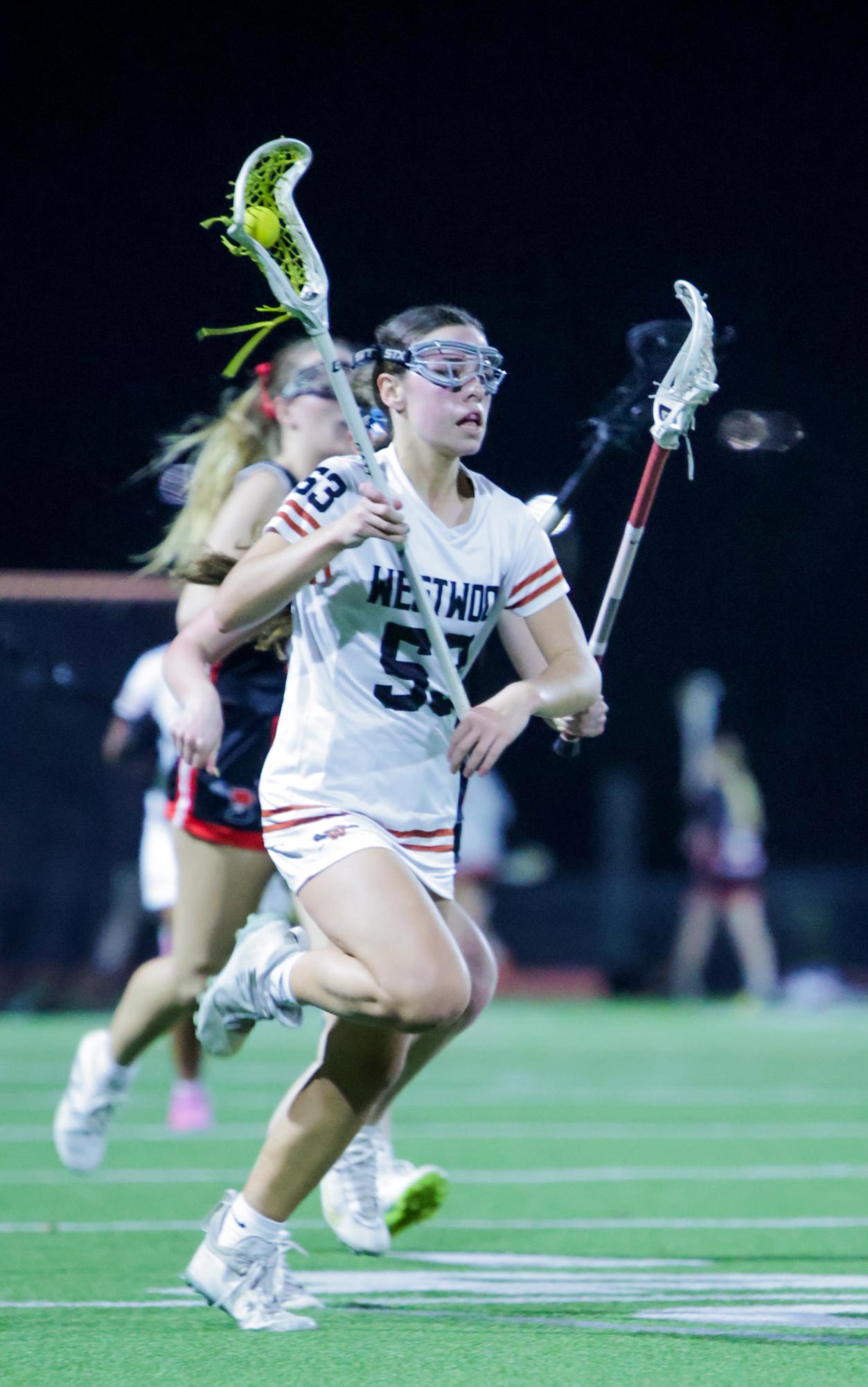 Moving down the field, Bonnie Rose Hance '29 cradles the ball, defenders behind her. As the only freshman on the Varsity team, Hance was able to use the season opener to sharpen her lacrosse skills for the season ahead. 