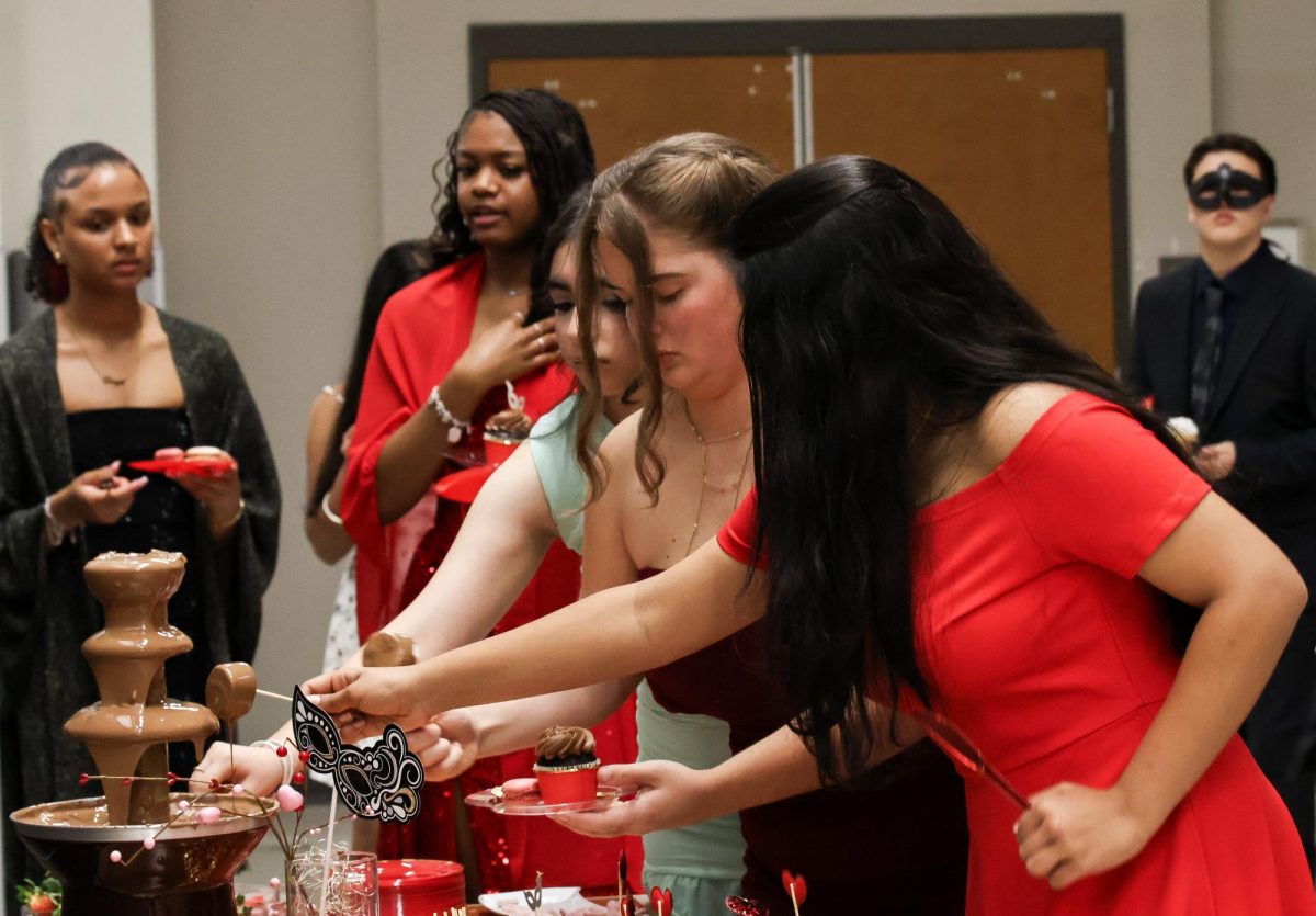 Reaching to the chocolate fountain, cadets enjoy the desserts offered at the military ball. Compared to the last military ball, more cadets showed up to recognize each other.